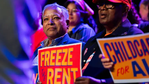 Сторонник Мамдани с плакатом «Заморозьте арендную плату»